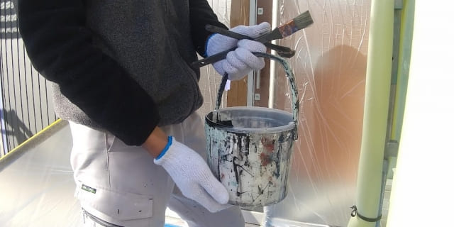外壁塗装の見積り前に施工範囲を確認する作業員のイメージ
